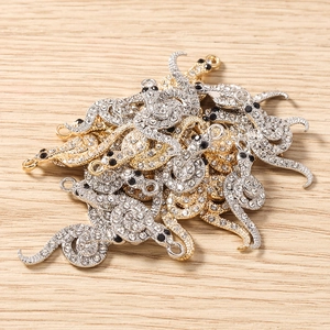 Gros plan de pendentifs pieuvre en strass pour bijoux DIY, finitions dorées et argentées