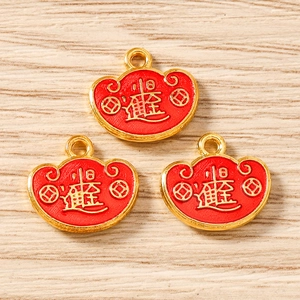 Macro detail of golden metal lucky pouch charms with red enamel and Chinese characters