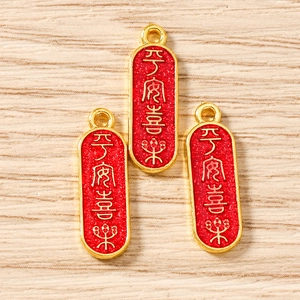 Macro shot of red glitter lucky bag charms with gold Ping An Xi Le chinese characters