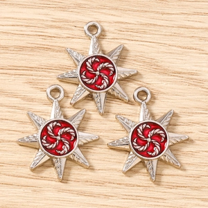 Macro shot of silver octagonal star pendants with red swirl engraving for DIY jewelry