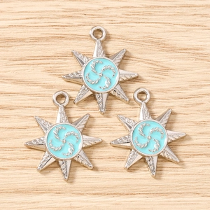Macro shot of silver eight-pointed star pendants with light blue enamel for DIY jewelry