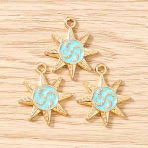 Detailed macro view of three golden star pendants with blue enamel spiral texture for DIY jewelry