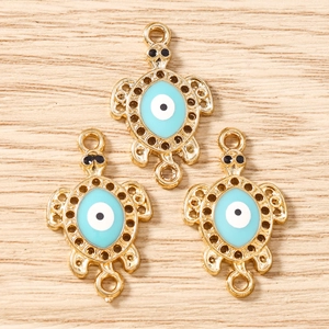 Detailed view of turtle connectors with evil eye enamel for DIY jewelry making