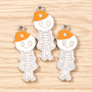 Détail de trois pendentifs tête de mort avec chapeaux orange pour bijoux DIY