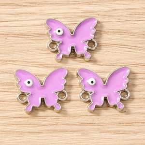 Macro view of purple enamel butterfly charms with eye detail for DIY jewelry making