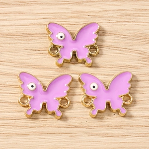 Macro detail of purple butterfly charms with eye pattern and golden metal loops