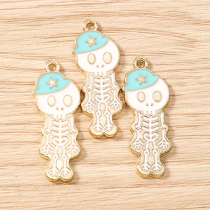 Détail de trois breloques squelettes avec chapeaux bleus pour la création de bijoux DIY