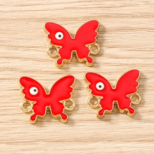 Detail view of red butterfly enamel connectors with gold edges and double loops for DIY jewelry