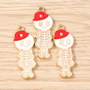 Détail macro de pendentifs squelette avec chapeau rouge et étoiles dorées sur bois