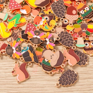 Detailansicht bunter Emaille-Herbstanhänger wie Eichhörnchen und Truthahn für DIY-Schmuck