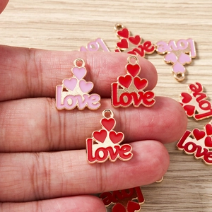 Macro detail of red and pink LOVE heart alloy charms for DIY jewelry making