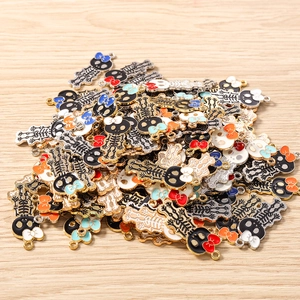 Macro shot of colorful enamel skull charms with bows on a light wooden background