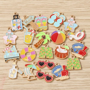 Pendentifs d'été en émail avec palmiers et tongs sur un fond en bois de ton naturel
