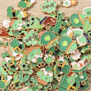 Detailed macro of green St. Patrick's Day clover and hat enamel charms on wood