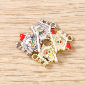 Detailed macro view of enamel Christmas house charms with gold and silver alloy plating