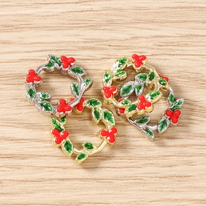Macro shot of holly berry enamel pendants with gold and silver frames for DIY crafts