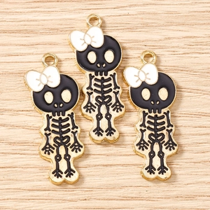 Macro detail of cartoon skeleton charms with white bows and black enamel for DIY jewelry