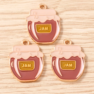 Makroaufnahme von drei rosa Marmeladenglas-Anhängern für DIY-Schmuck auf Holzgrund