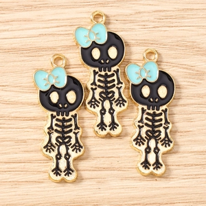 Macro shot of skull alloy charms with blue bows and gold accents on wood background