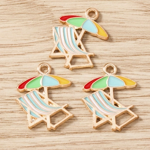 Vue détaillée de pendentifs émaillés en forme de chaise de plage et parasol sur bois