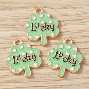 Detail of green four-leaf clover lucky charms with gold edges for jewelry making
