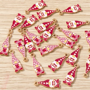 Macro detail of Christmas gnome enamel pendants with red and pink heart hats on wood