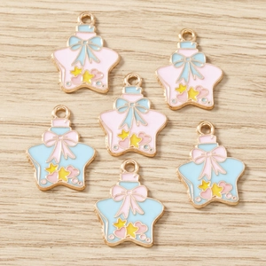 Vue détaillée des pendentifs flacons étoilés avec bords dorés et émail bleu et rose
