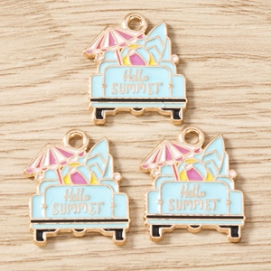 Détail de pendentifs d'été en émail avec voiture de plage et planche de surf sur bois