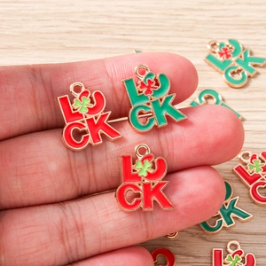 Vue détaillée de breloques trèfle à quatre feuilles en émail rouge et vert pour bijoux