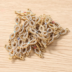 Nahaufnahme goldener Infinity-Böser-Blick-Anhänger mit Strass für DIY-Schmuckherstellung