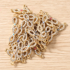 Makroaufnahme von vergoldeten Unendlichkeits-Anhänger-Charms mit funkelnden Kristallen für DIY