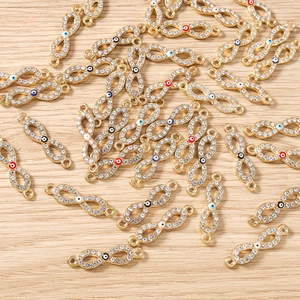 Detail von Unendlichkeit-Anhängern in Gold mit bunten Augen und Kristallen für DIY-Schmuck