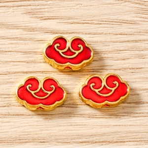 Detailansicht von drei chinesischen Wolken-Anhängern in Rot und Gold auf Holzgrund