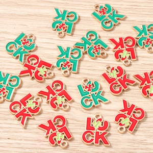 Détail des pendentifs LUCK avec finition émaillée et motif de trèfle à quatre feuilles