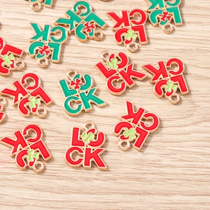 Vue détaillée des pendentifs LUCKY dorés avec trèfle émaillé rouge et vert pour bijoux DIY
