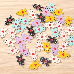 Macro shot of colorful voodoo doll enamel alloy pendants with red heart for DIY jewelry