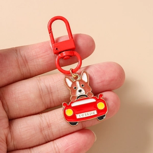 Dettaglio portachiavi smaltato Corgi alla guida di un'auto rossa con scritta I DRIVE