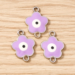 Dettaglio di ciondoli a fiore di ciliegio viola con occhio greco per creazione gioielli