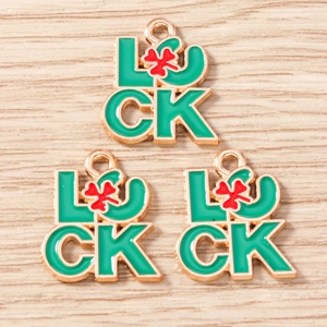 Détail macro de charms porte-bonheur en alliage avec texte Luck émaillé vert et trèfle