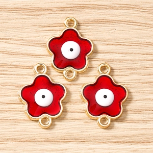 Dettaglio di ciondoli evil eye a forma di fiore rosso con doppi anelli per il fai da te