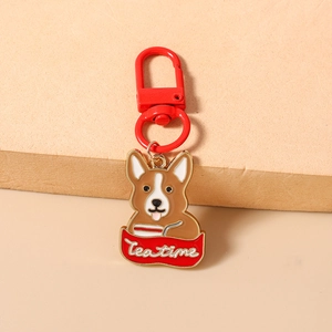 Dettaglio del portachiavi smaltato a forma di Corgi con scritta Tea Time e gancio rosso