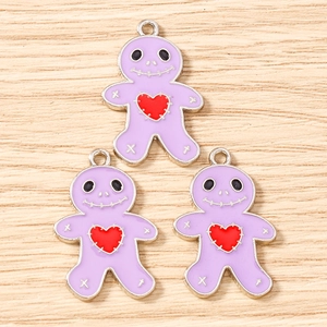 Macro detail of three purple gingerbread man alloy charms with heart and silver edges