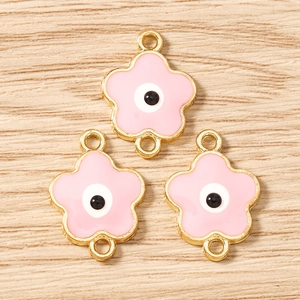Dettaglio di ciondoli a fiore di ciliegio rosa con malocchio e placcatura in oro