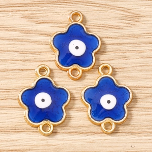 Dettaglio dei ciondoli a fiore di ciliegio blu con bordi in metallo dorato e anelli