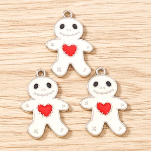 Detail of white skeleton gingerbread man charms with red hearts for jewelry making
