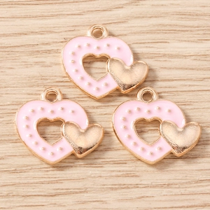 Détail de breloques double cœur en émail rose avec accents dorés pour bijoux DIY