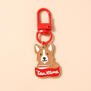 Dettaglio del portachiavi a forma di cane Corgi con scritta Tea Time e moschettone rosso
