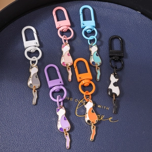Close-up of colorful cartoon cat keychains with moving tails on a deep blue tray