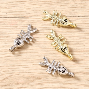Gedetailleerde macro-opname van visgraat bedeltjes in goud en zilver voor DIY sieraden