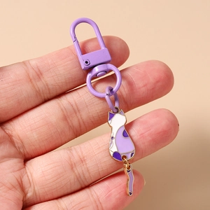 Detail of purple enamel cat keychain with movable tail and matching lobster clasp